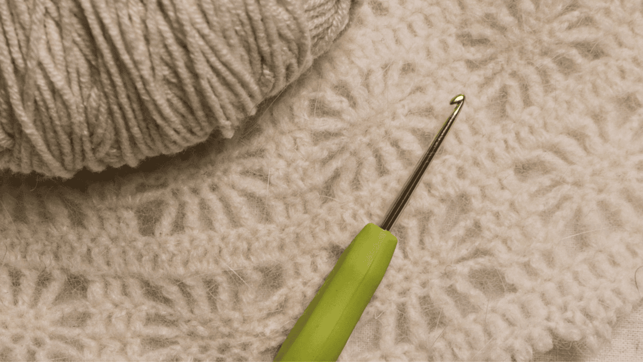 A crocheted mohair swatch where the halo softens the stitch pattern, shown with a smooth non mohair yarn laid on top for comparison